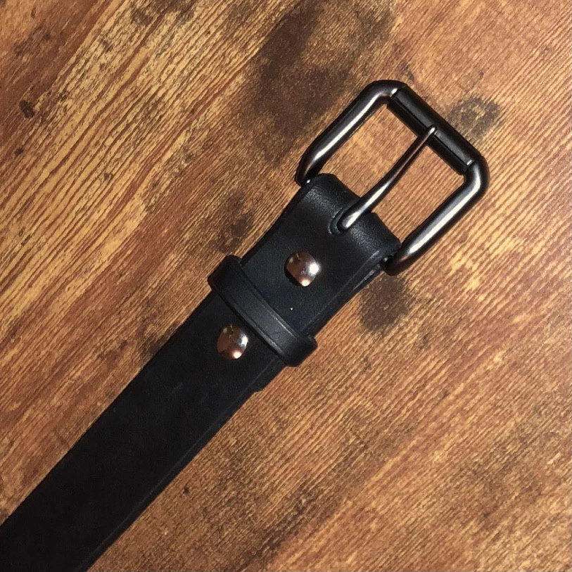 Customer photo submitted with Lanie's Etsy review showing a black Moonlight Leatherworks belt on a wood surface.